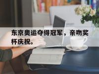 九游游戏中心网页版-东京奥运夺得冠军，亲吻奖杯庆祝。